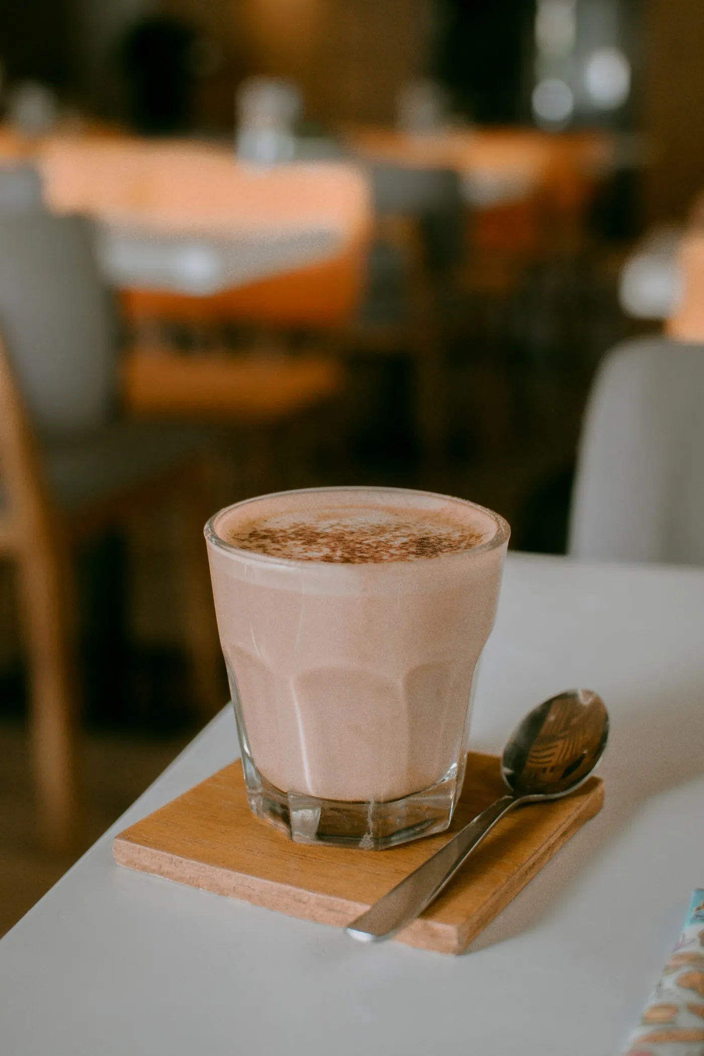 Iced chai latte in a clear glass on a stone surface